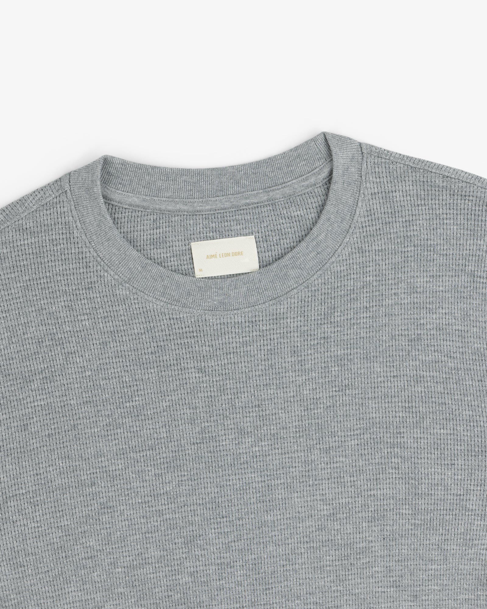 A close-up of a light gray Long-Sleeve Waffle Thermal with a ribbed crewneck and beige label inside the collar.