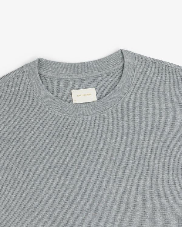 A close-up of a light gray Long-Sleeve Waffle Thermal with a ribbed crewneck and beige label inside the collar.