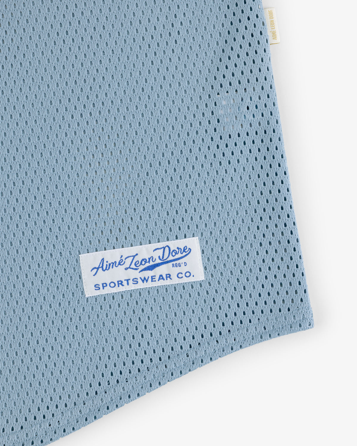Close-up of a light blue Mesh Batting Practice Jersey with an Aimé Leon Dore Sportswear Co. label sewn on.