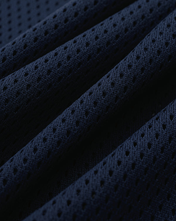 Close-up of the Mesh Batting Practice Jersey’s dark blue perforated fabric with ridges and breathable holes.