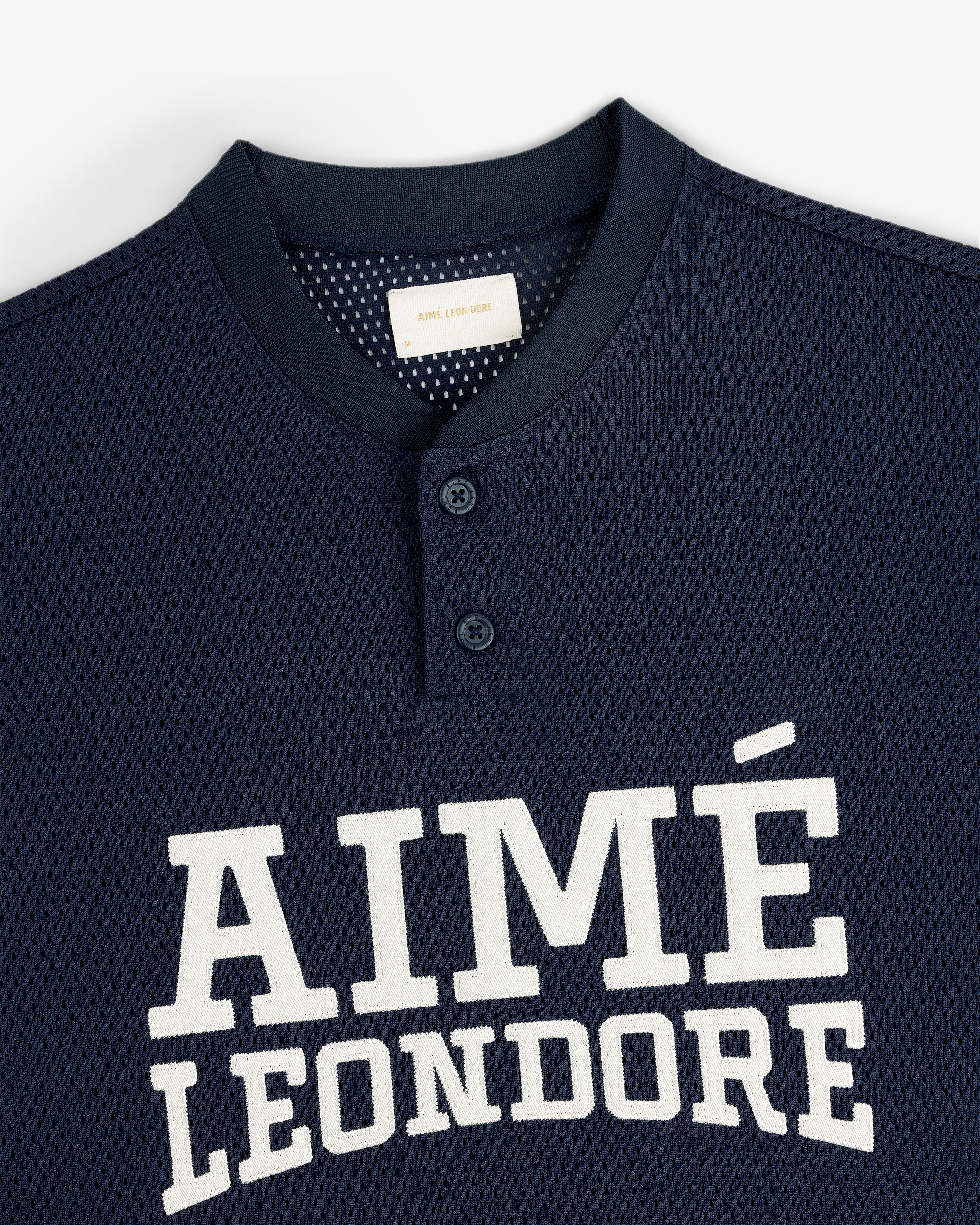 Navy blue Mesh Batting Practice Jersey with AIMÉ LEON DORE in white and two buttons near the collar.