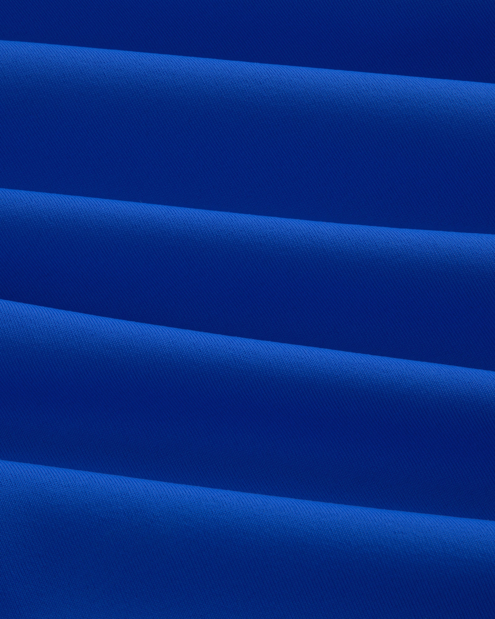 Close-up of evenly folded Short Sleeve Crest Rash Guard, forming horizontal ridges and shadows.