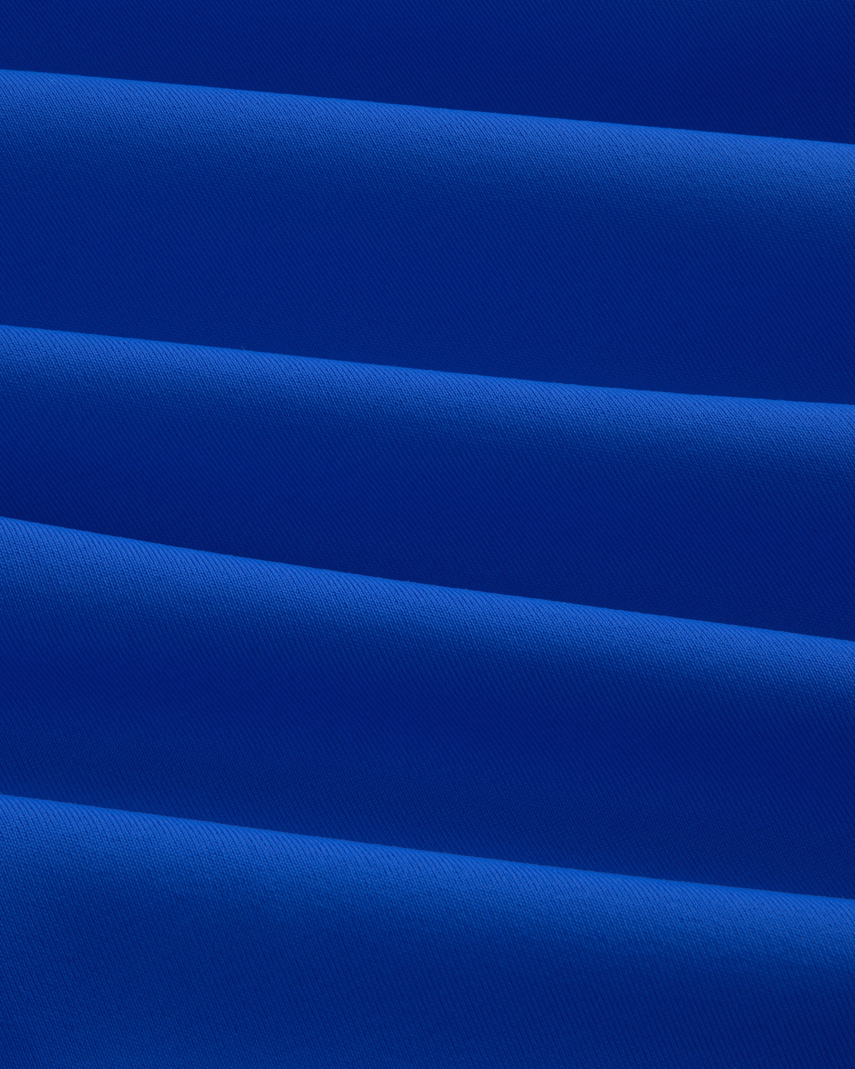 Close-up of evenly folded Short Sleeve Crest Rash Guard, forming horizontal ridges and shadows.