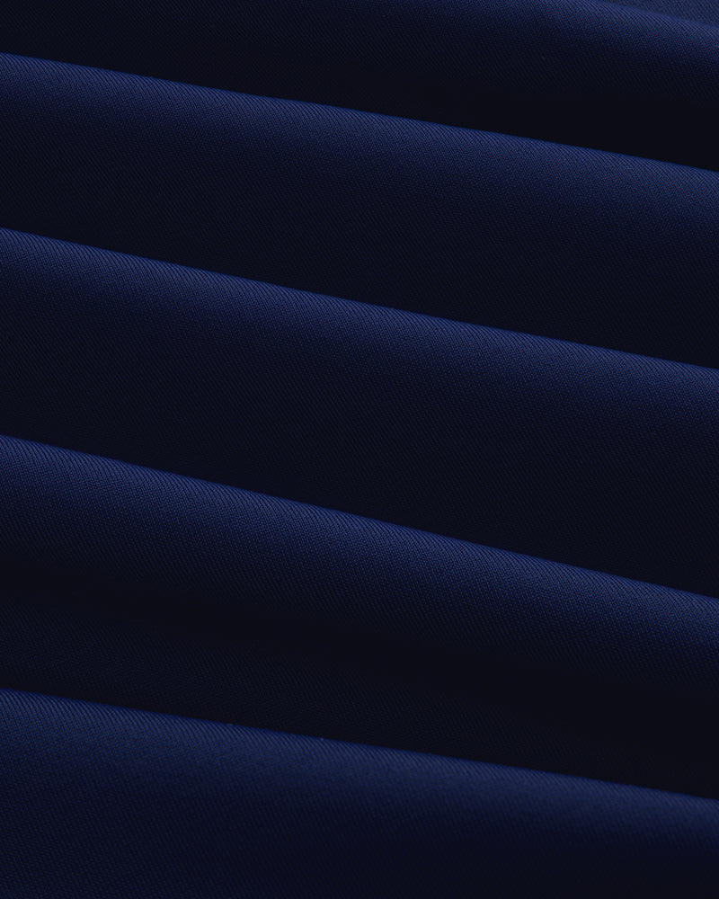 Close-up of Short Sleeve Crest Rash Guard in dark blue with diagonal folds creating light and shadow patterns.