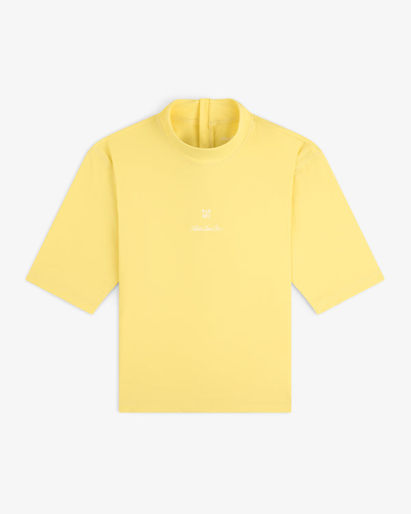 Short Sleeve Crest Rash Guard in light yellow with small white logo and text on chest, shown on white background.