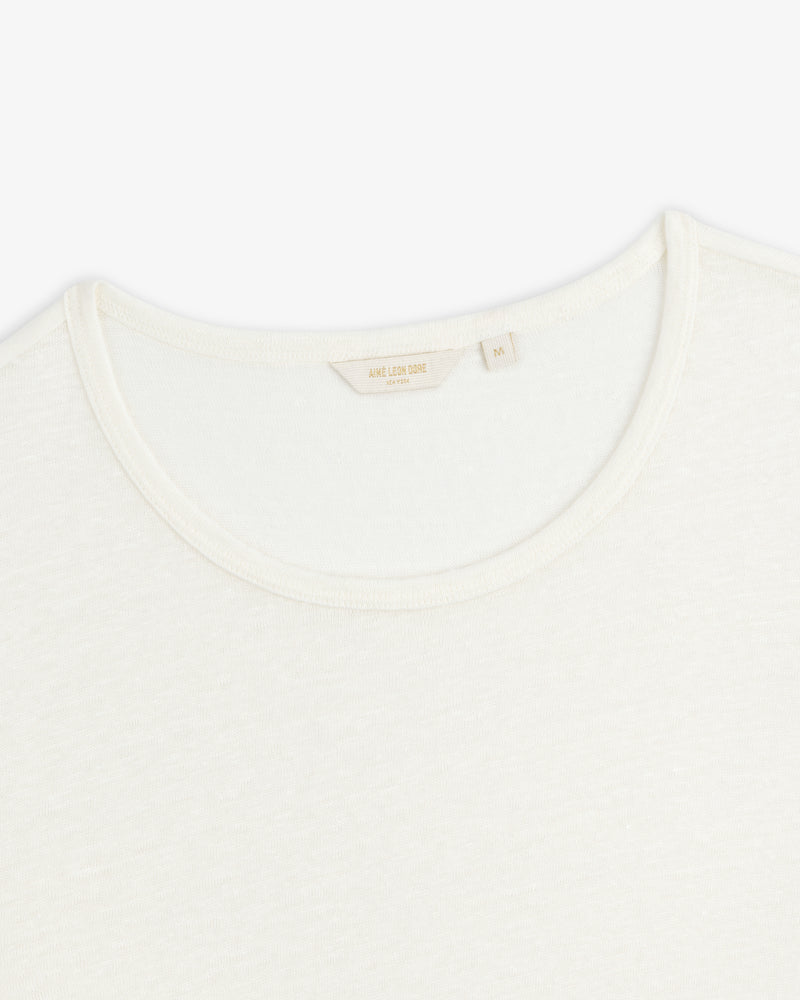 Close-up of the neckline of a plain white Linen Tee crew neck on a white background.