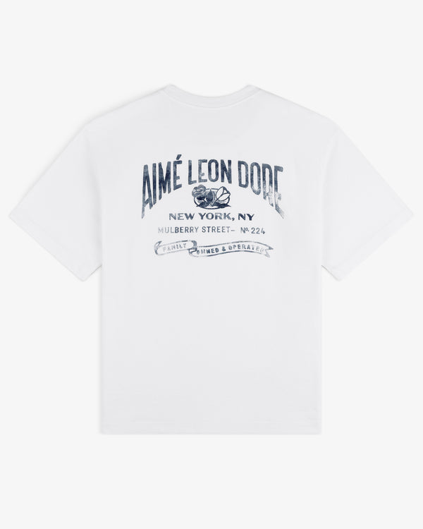 Neighborhood Pocket Tee featuring Aimé Leon Dore New York, NY and blue decorative text printed on the back.