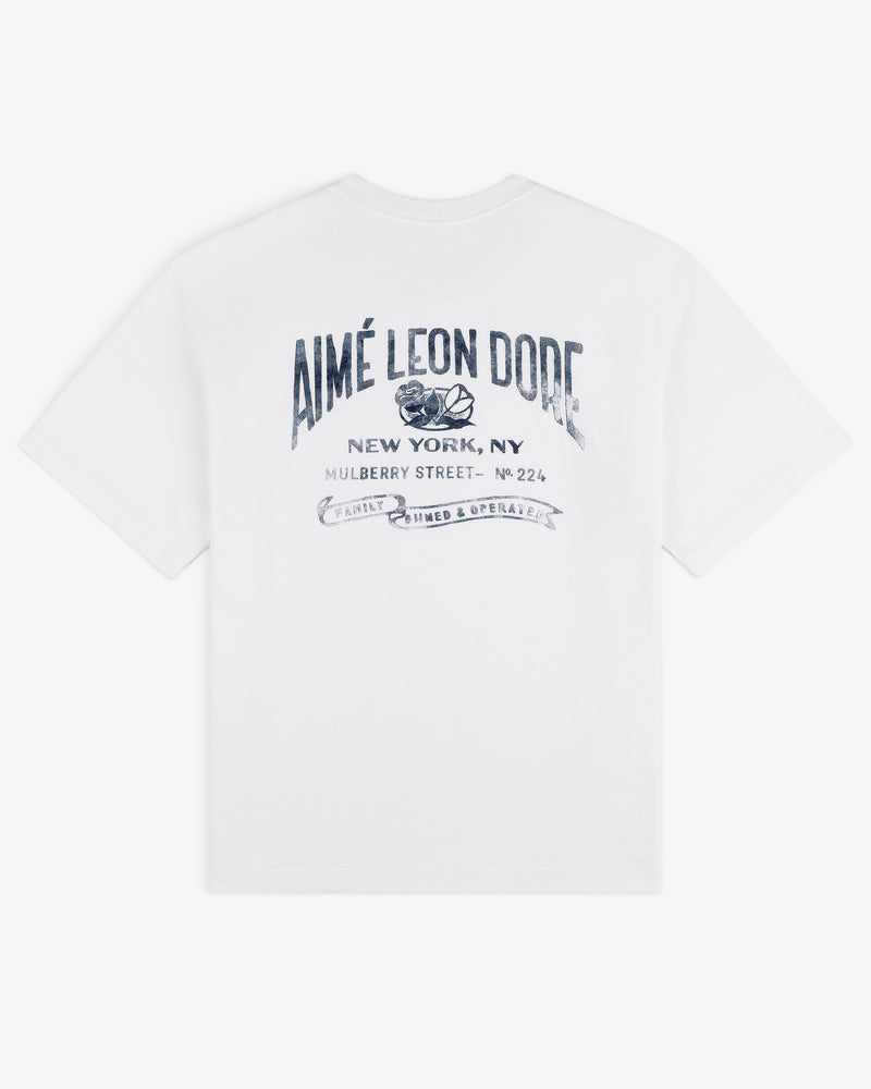 Neighborhood Pocket Tee featuring Aimé Leon Dore New York, NY and blue decorative text printed on the back.
