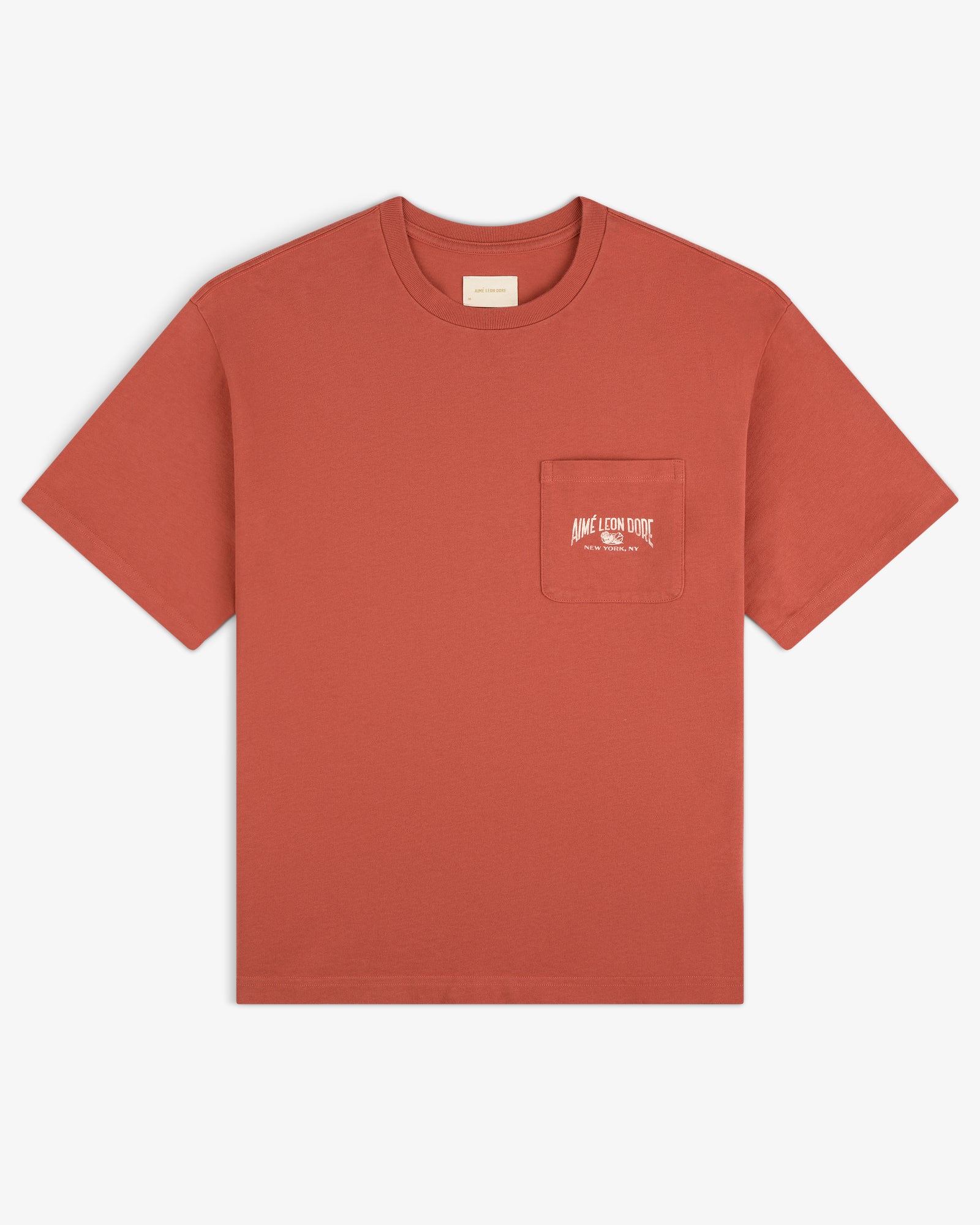 Neighborhood Pocket Tee in rust red, features a chest pocket with small white text printed on the pocket.