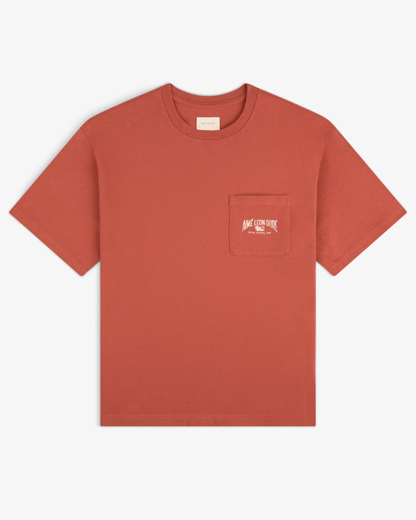 Neighborhood Pocket Tee in rust red, features a chest pocket with small white text printed on the pocket.