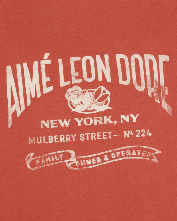 Red Neighborhood Pocket Tee with white text: Aimé Leon Dore, New York, Mulberry Street No. 224, Family Owned & Operated.