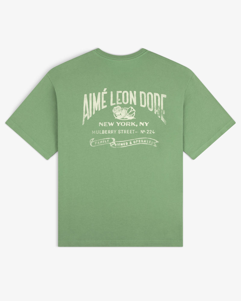 Neighborhood Pocket Tee featuring “Aimé Leon Dore New York, NY Mulberry Street” graphic text in white on the back.
