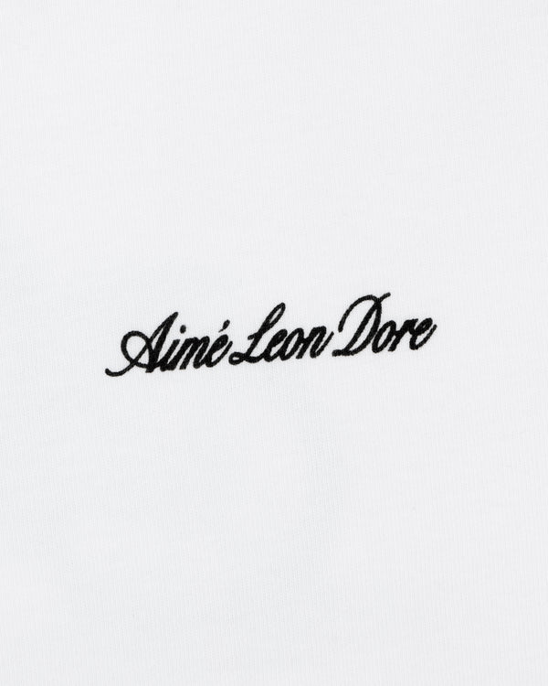 Black script "Aimé Leon Dore" embroidered on a plain white Super Cub Tee.