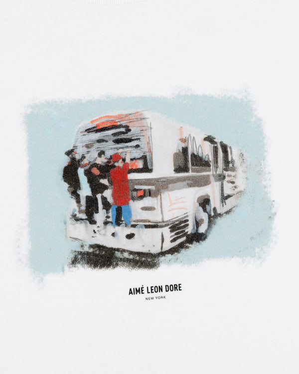 Illustration of people boarding a white bus with "Mesaikos Commuter Tee" text below on a white background.