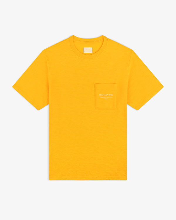 Artiste Pocket Tee: bright yellow short-sleeve shirt with chest pocket and subtle logo text on the pocket.