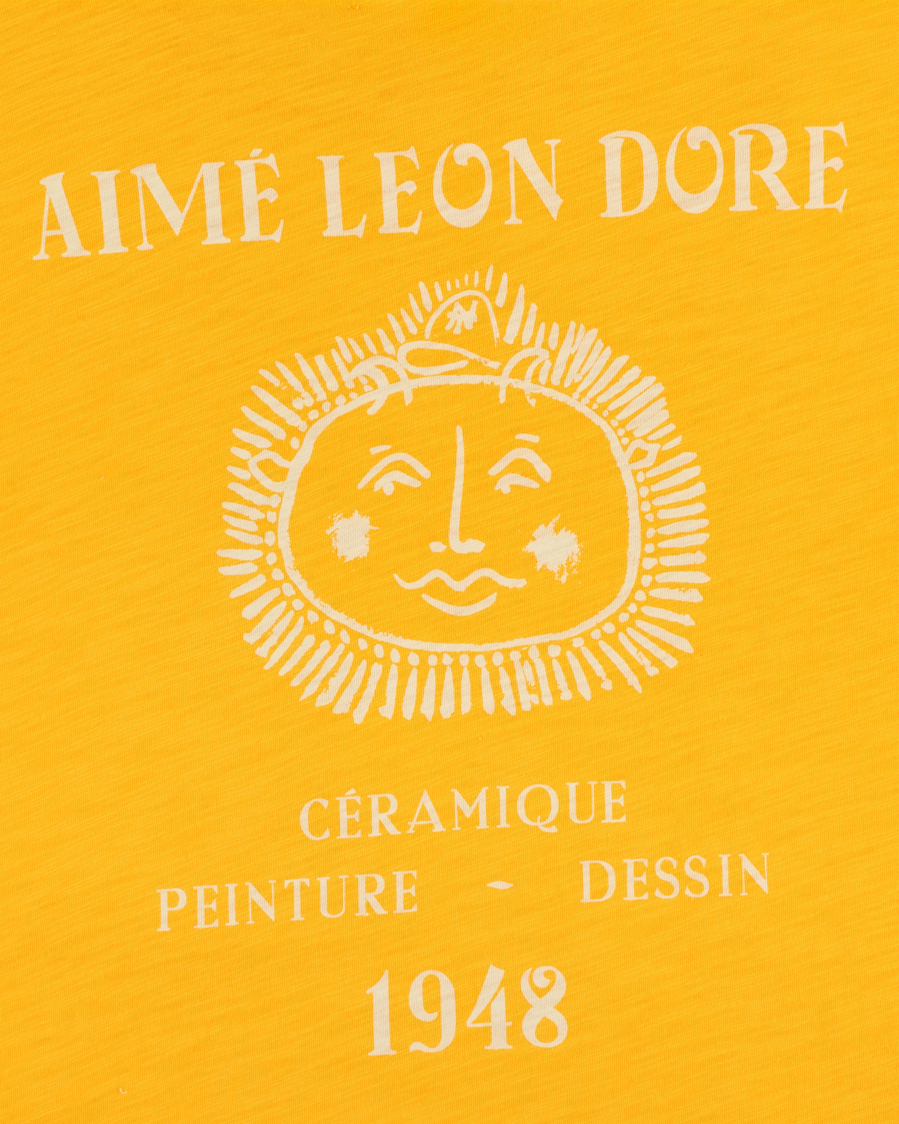 Yellow background, white Aimé Leon Dore text, sun face, Céramique Peinture Dessin 1948 on Artiste Pocket Tee.