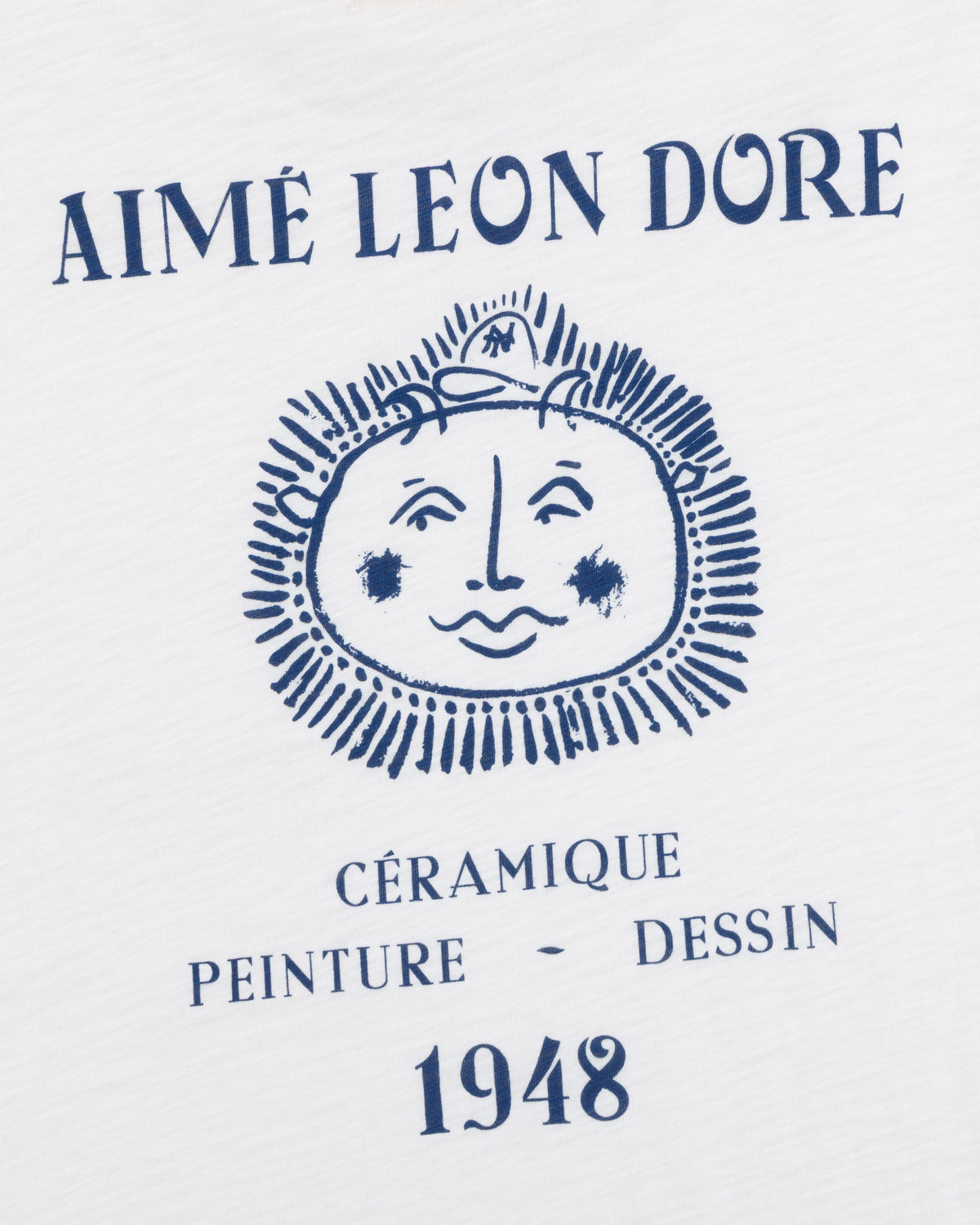 White Artiste Pocket Tee with AIMÉ LEON DORE above a sun face and CÉRAMIQUE PEINTURE DESSIN 1948 below.