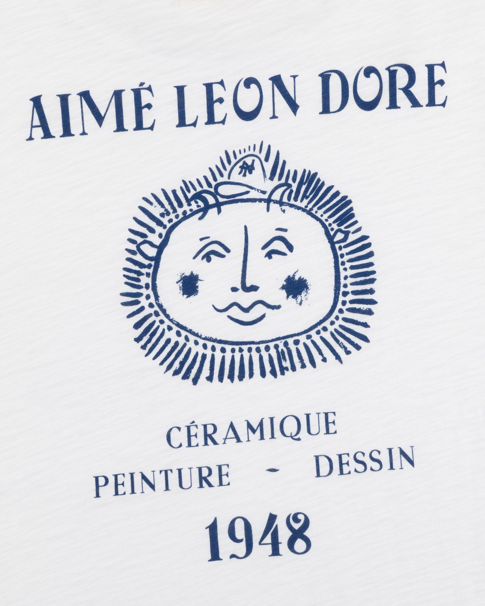 White Artiste Pocket Tee with AIMÉ LEON DORE above a sun face and CÉRAMIQUE PEINTURE DESSIN 1948 below.