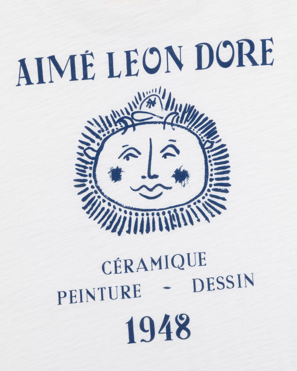 White Artiste Pocket Tee with AIMÉ LEON DORE above a sun face and CÉRAMIQUE PEINTURE DESSIN 1948 below.