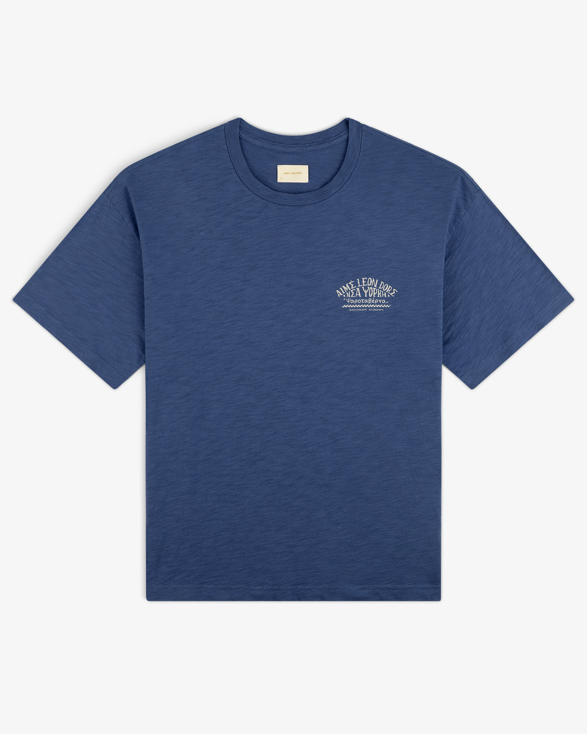 Taverna Tee in blue, short sleeves, with small white text logo on left chest, laid flat on white background.