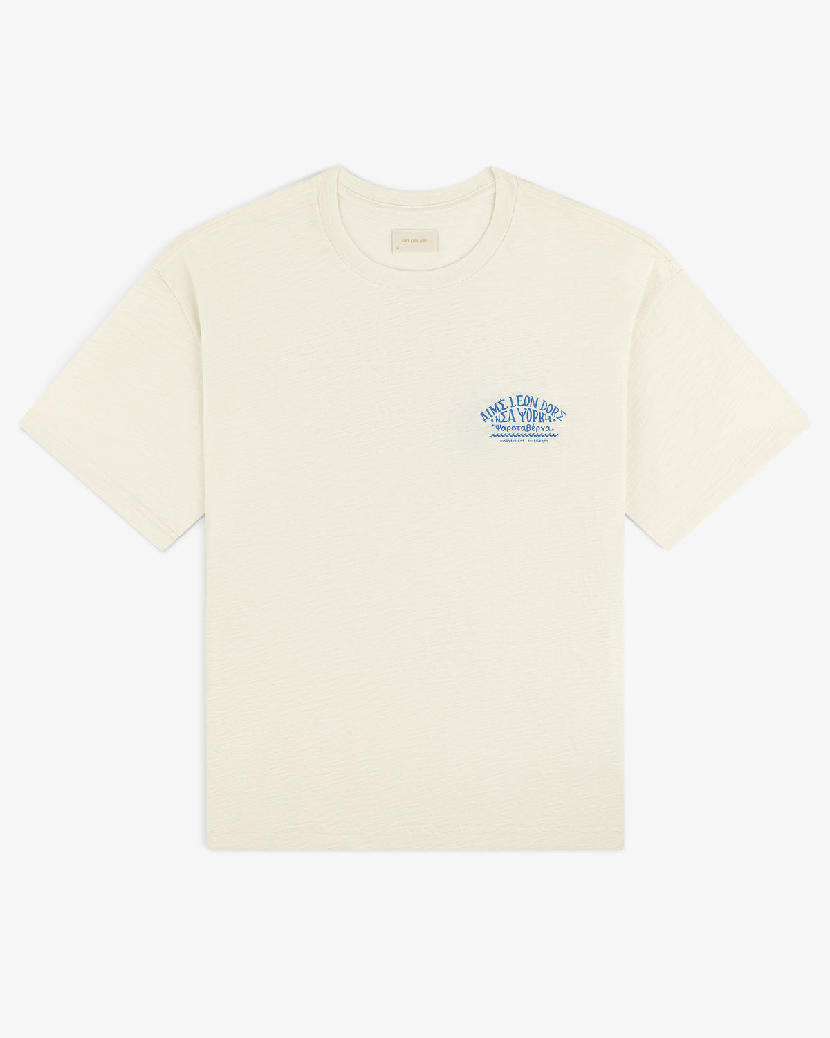 Taverna Tee: Cream short-sleeve shirt with small blue text and graphic on left chest.