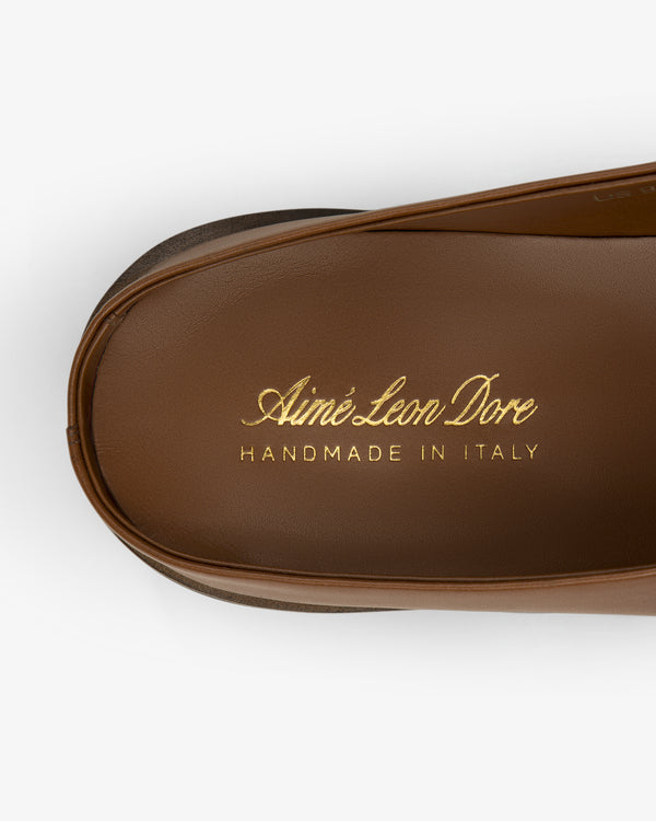Brown leather insole of the Venetian Mule with gold Aimé Leon Dore HANDMADE IN ITALY text on white background.