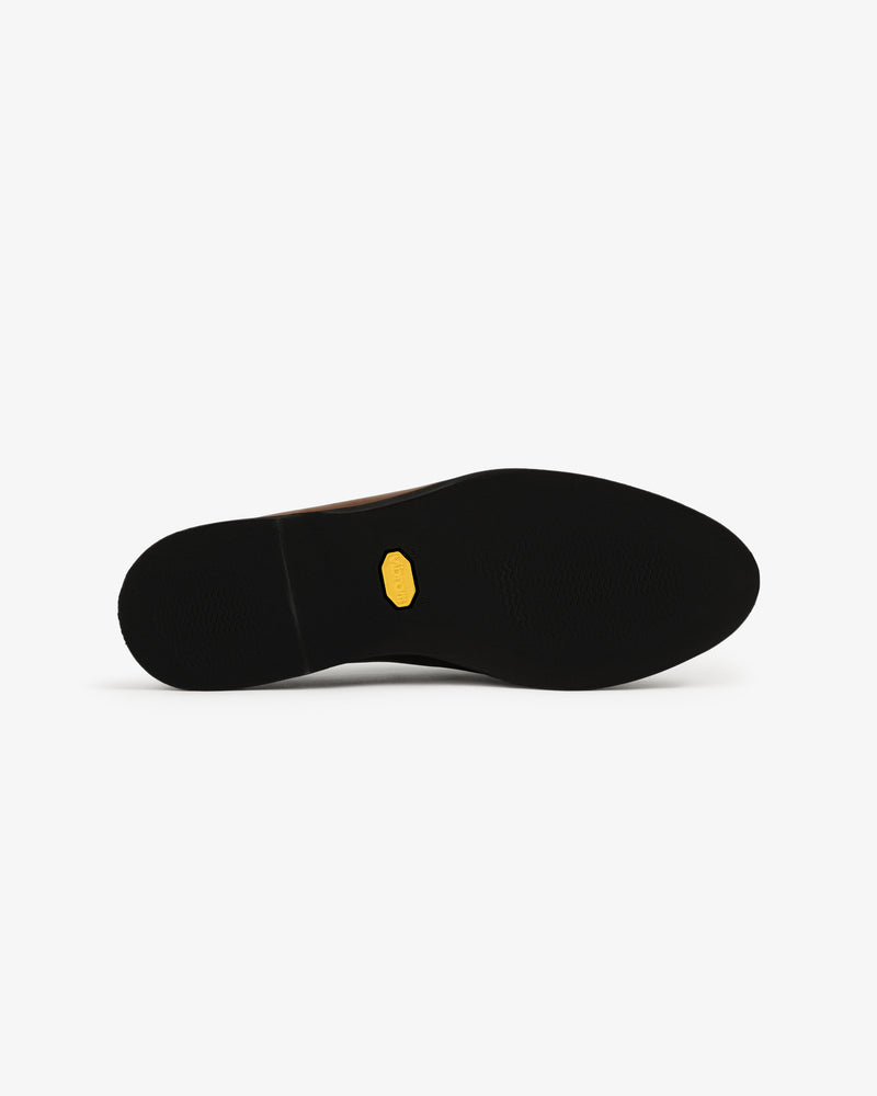 The Venetian Mule's black sole features a small yellow hexagonal logo at the center, viewed from below on white.