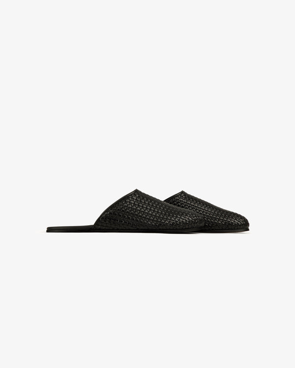 The Leather Raffia Mule is a black woven slip-on with pointed toes and flat soles, shown on a white background.