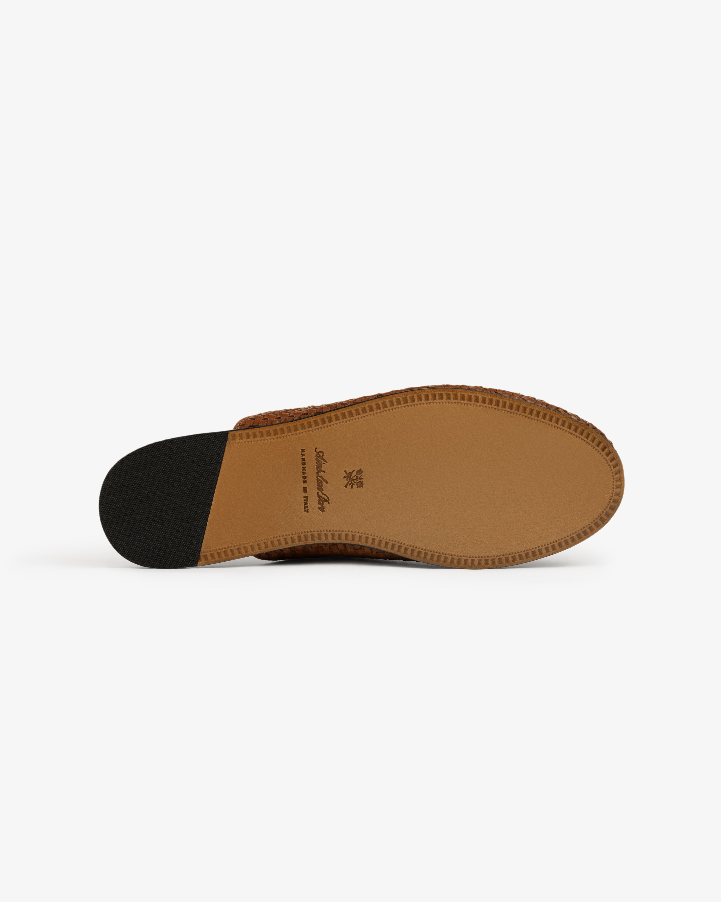 The sole of the Leather Raffia Mule, brown with a black heel and tan midsection, shown on a white background.