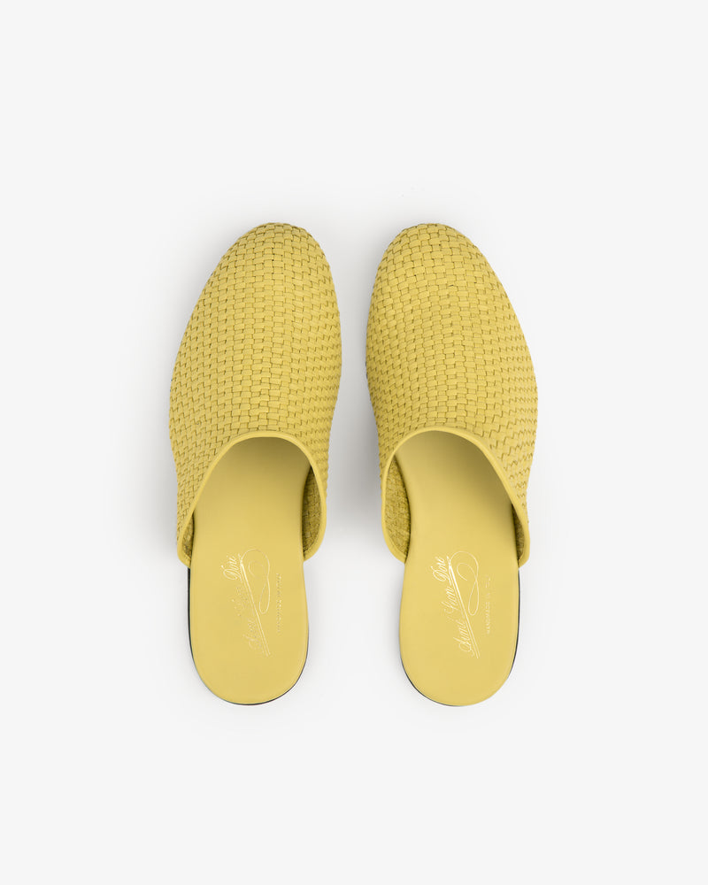 A pair of yellow Leather Raffia Mule slip-on shoes viewed from above on a white background.