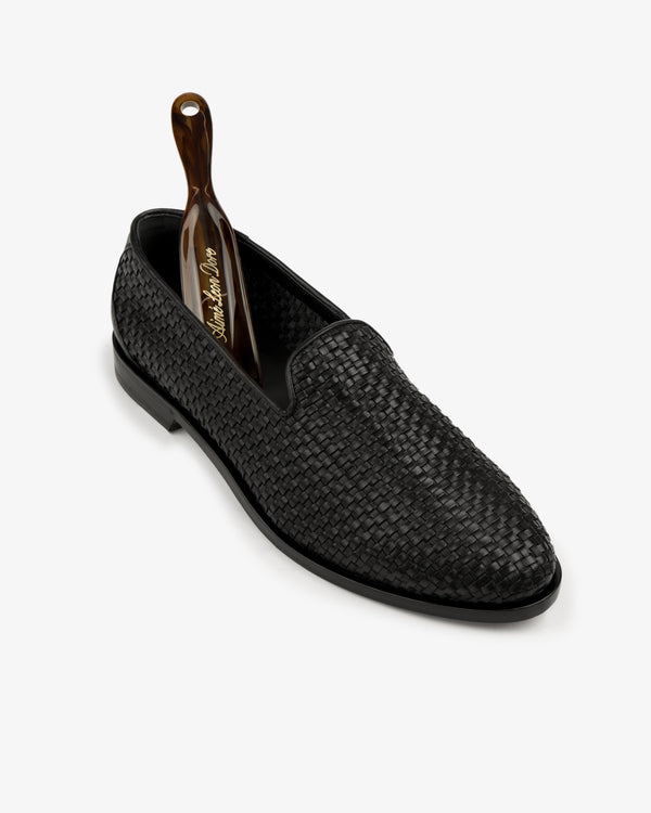 Leather Raffia Loafer with a brown shoehorn inserted, displayed on a white background.