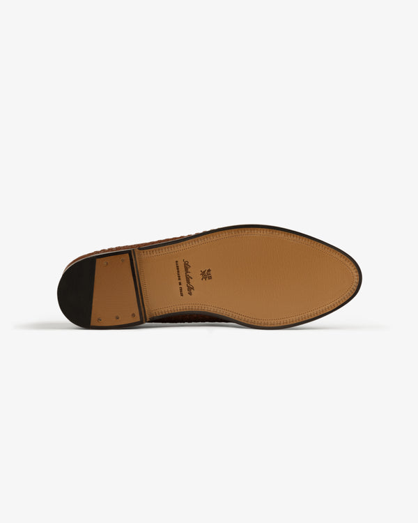 The Leather Raffia Loafer's brown leather sole is shown from the bottom against a white background.
