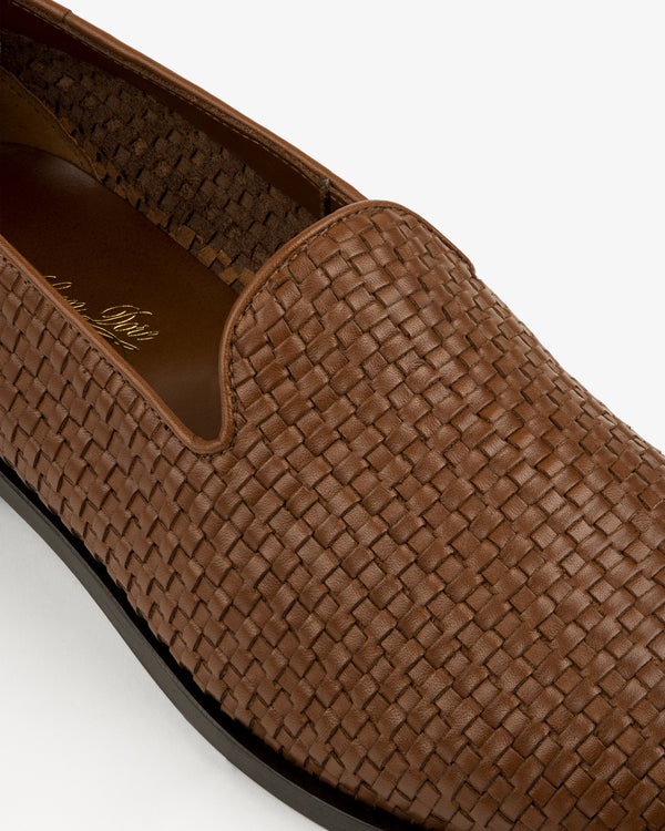Close-up of the Leather Raffia Loafer in brown, featuring a woven design, rounded toe, and black sole on white background.