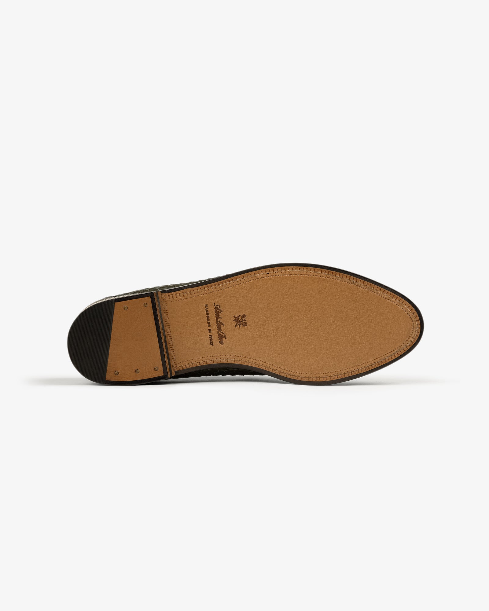 The sole of a Leather Raffia Loafer with a stacked heel and stitching, shown against a white background.