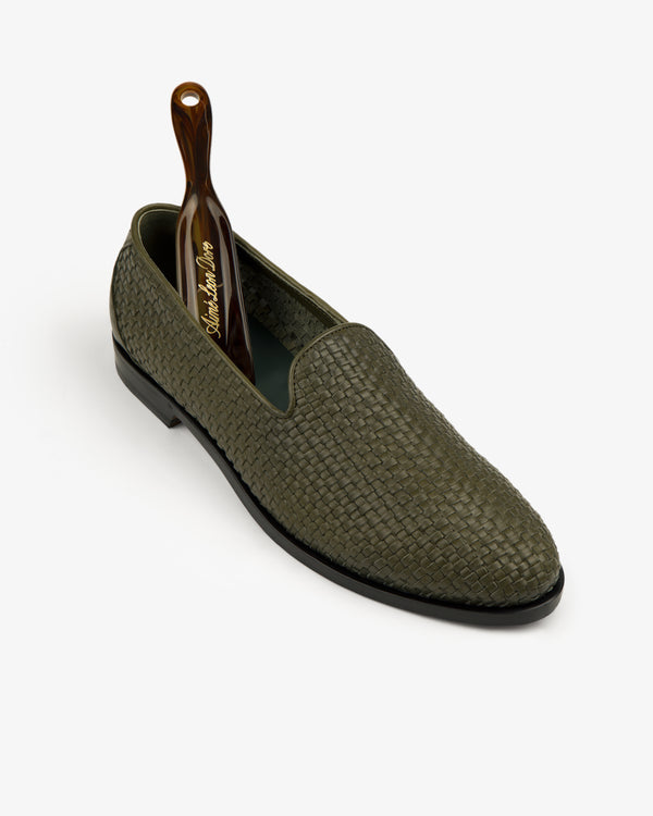 Leather Raffia Loafer in green with a brown shoehorn, displayed on a plain white background.