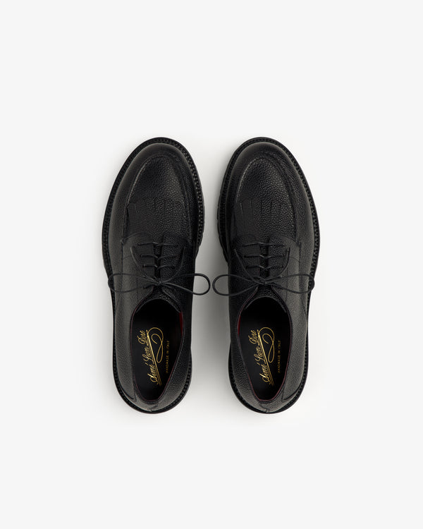 The Leather Lug Sole Derby, a pair of black lace-up dress shoes, is shown from above on a white background.