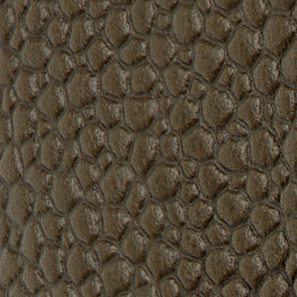 Close-up of textured, dark brown Leather Lug Sole Derby surface resembling reptile or crocodile skin.