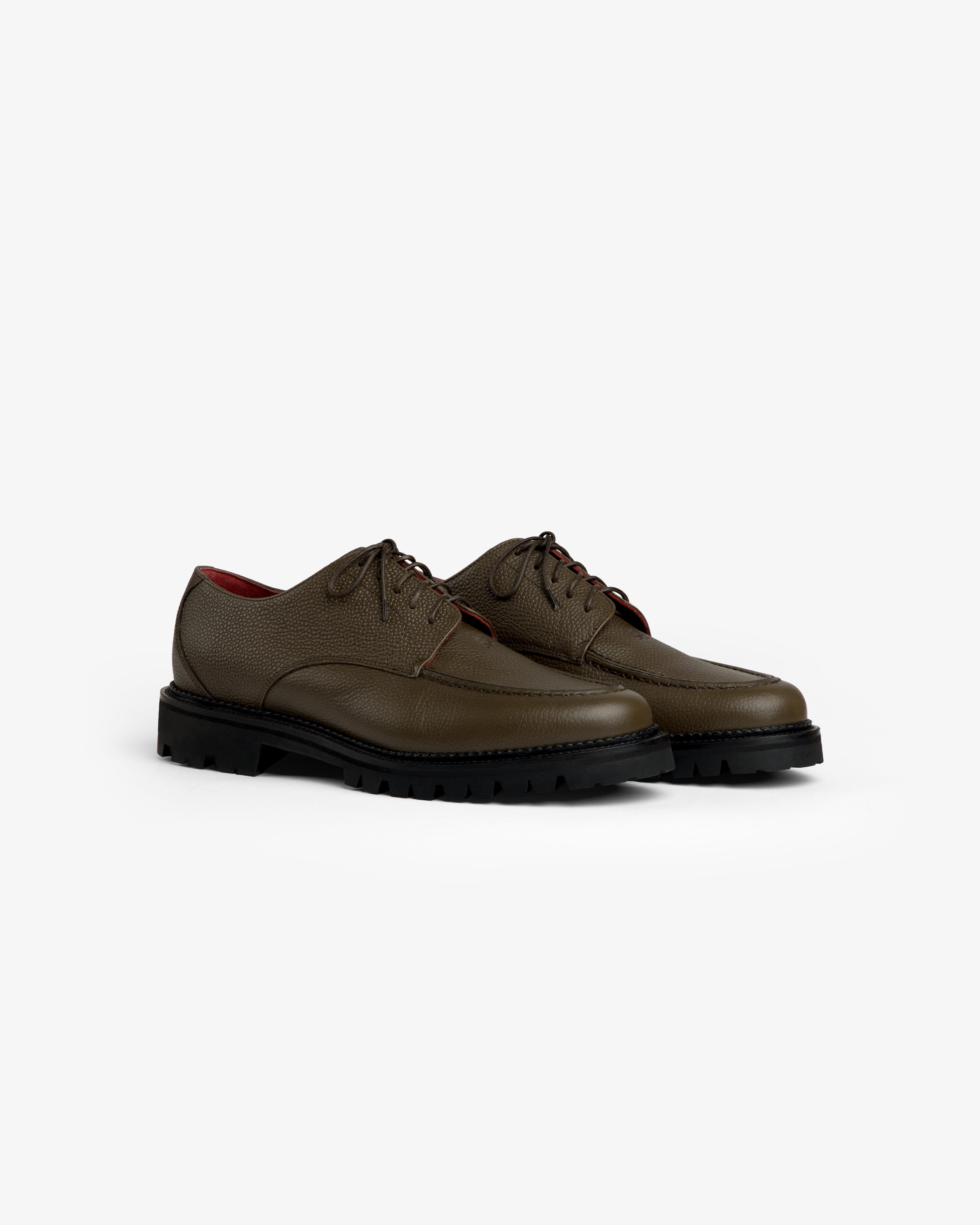Leather Lug Sole Derby shoes in olive green textured leather with thick black lug soles and lace-up closures.