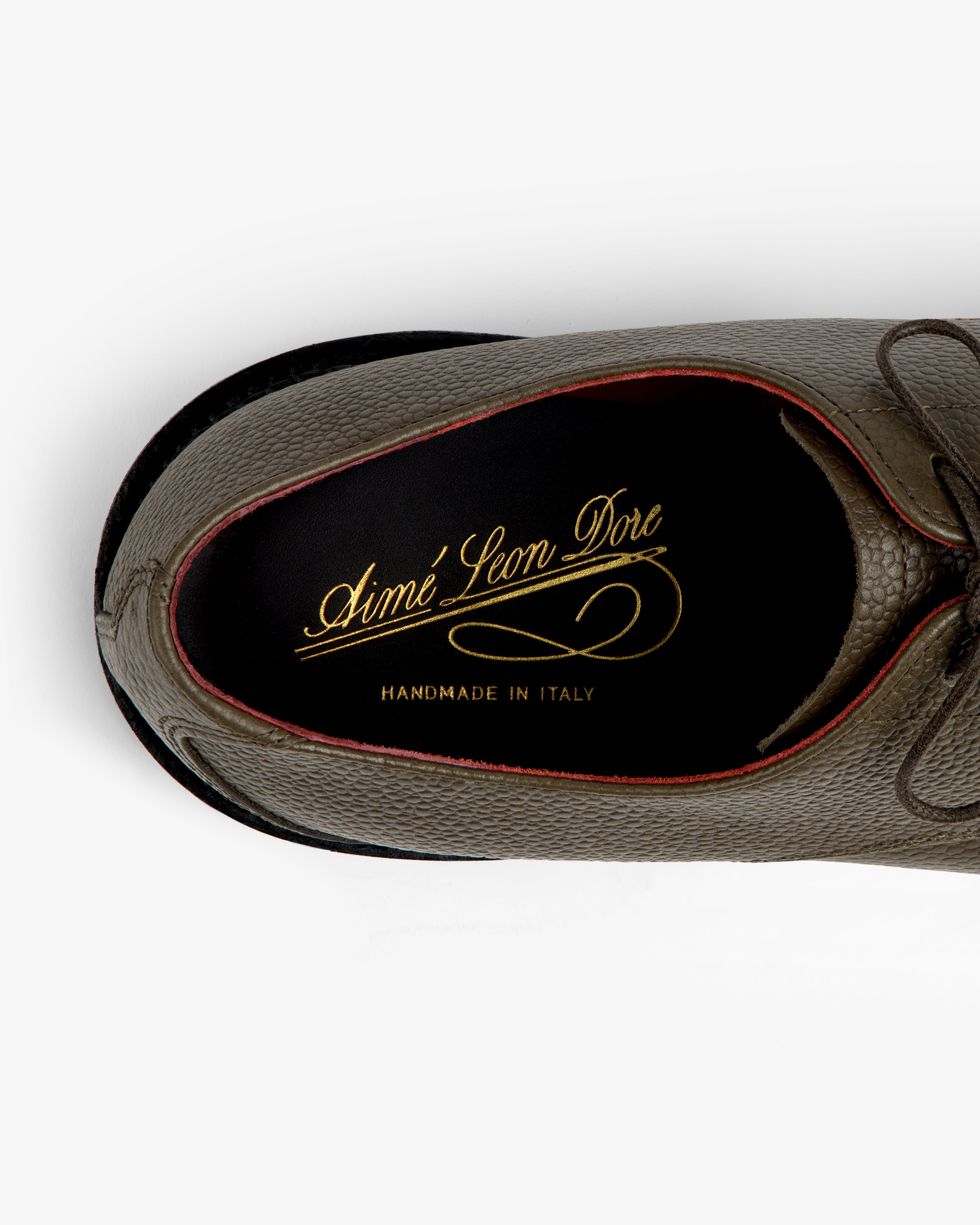 Top-down view of a textured olive Leather Lug Sole Derby interior with a gold brand logo on the insole.