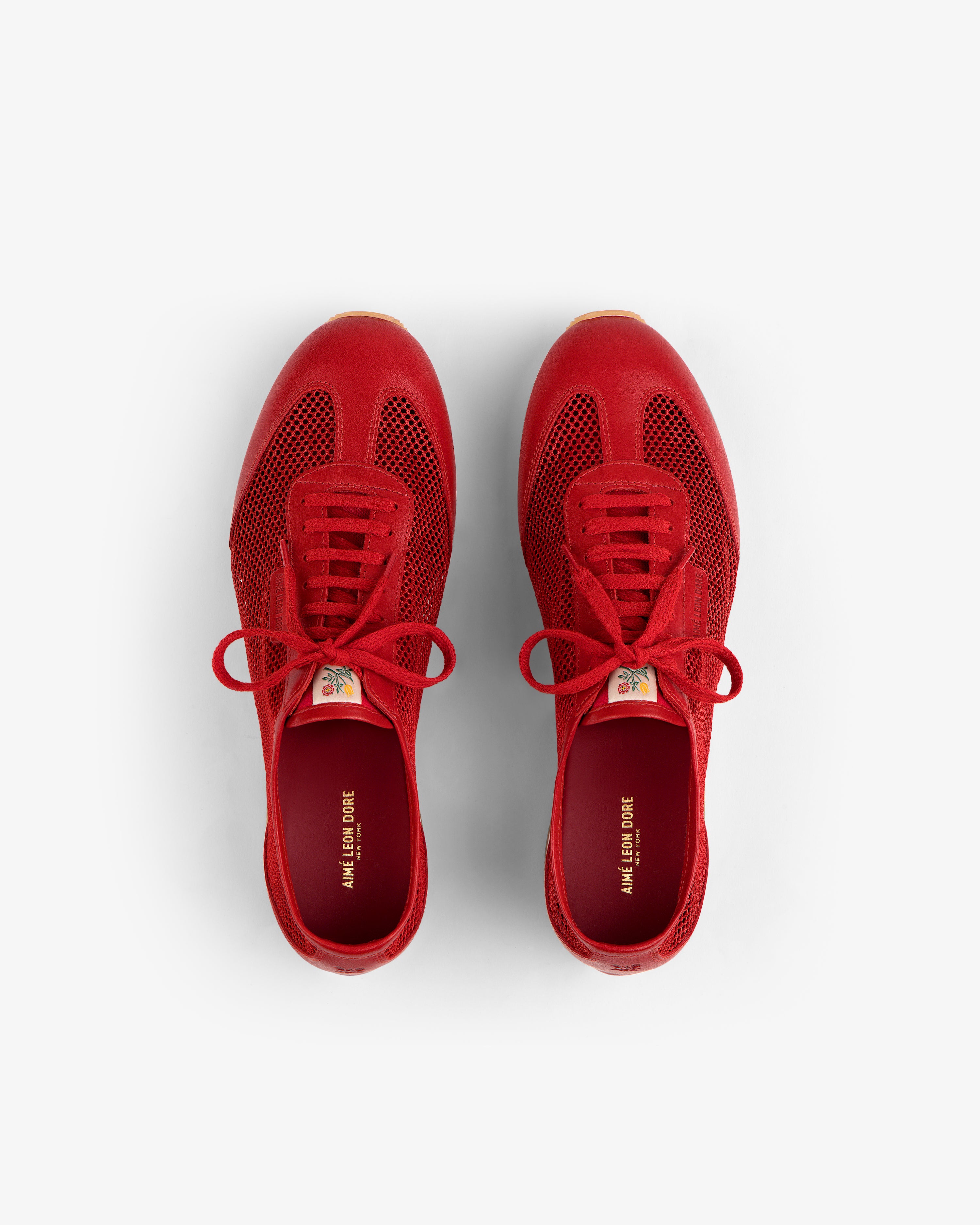 Low Profile Mesh Trainer in bright red, lace-up style, viewed from above on a white background.