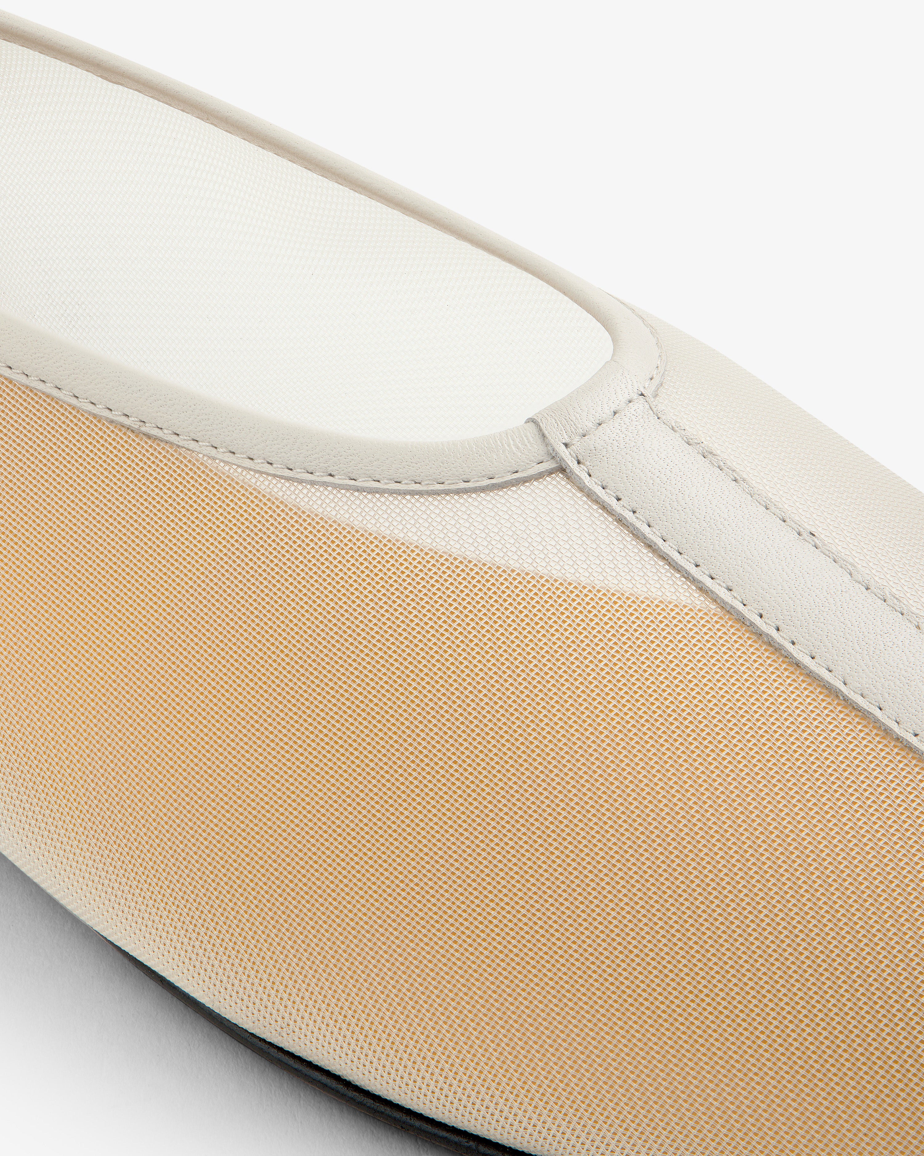 Close-up of the Mesh Ballet Flat, a beige and white slip-on with a textured fabric upper and smooth trim.