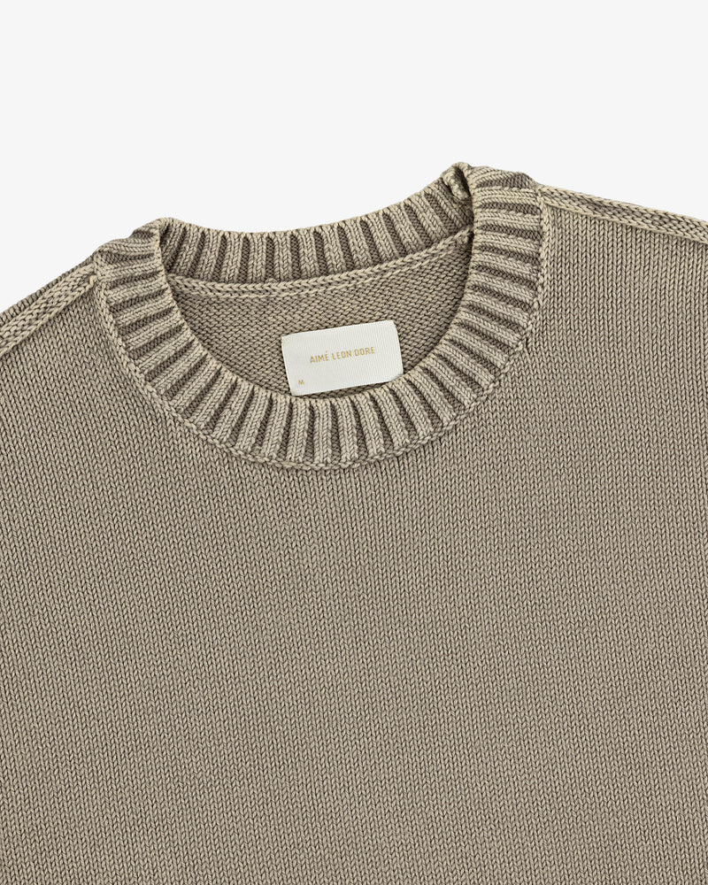 Washed Inside Out Sweater: Beige knit crewneck with ribbed collar and a white label at the neckline.