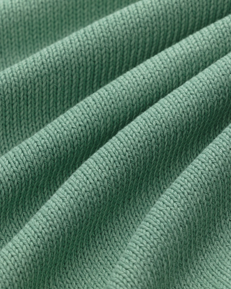 Close-up of the Washed Inside Out Sweater's green ribbed knit with textured, diagonal raised ridges.