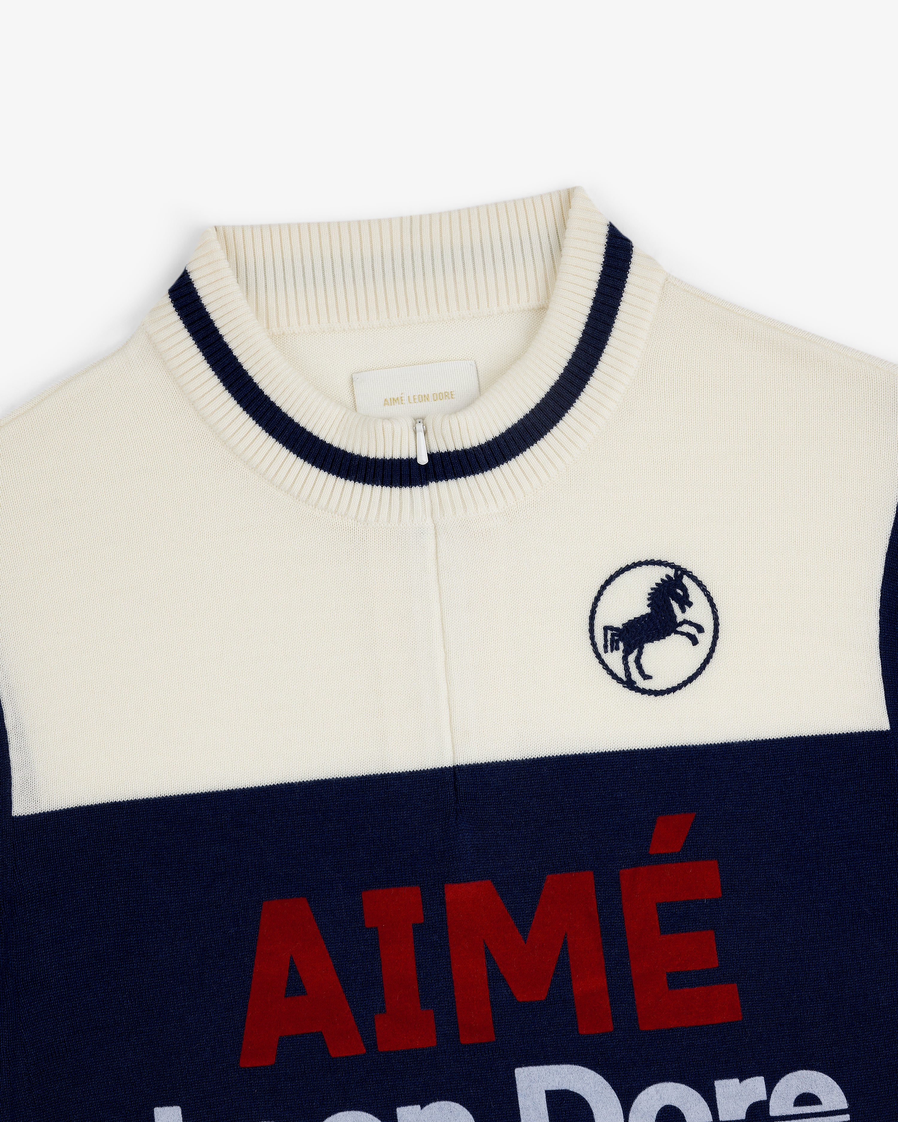 Merino Wool Cycling Jersey in cream/navy with ribbed collar, horse crest embroidery, and red "AIMÉ" on front.
