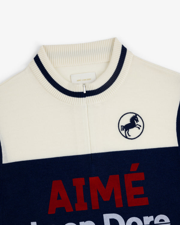 Merino Wool Cycling Jersey in cream/navy with ribbed collar, horse crest embroidery, and red "AIMÉ" on front.