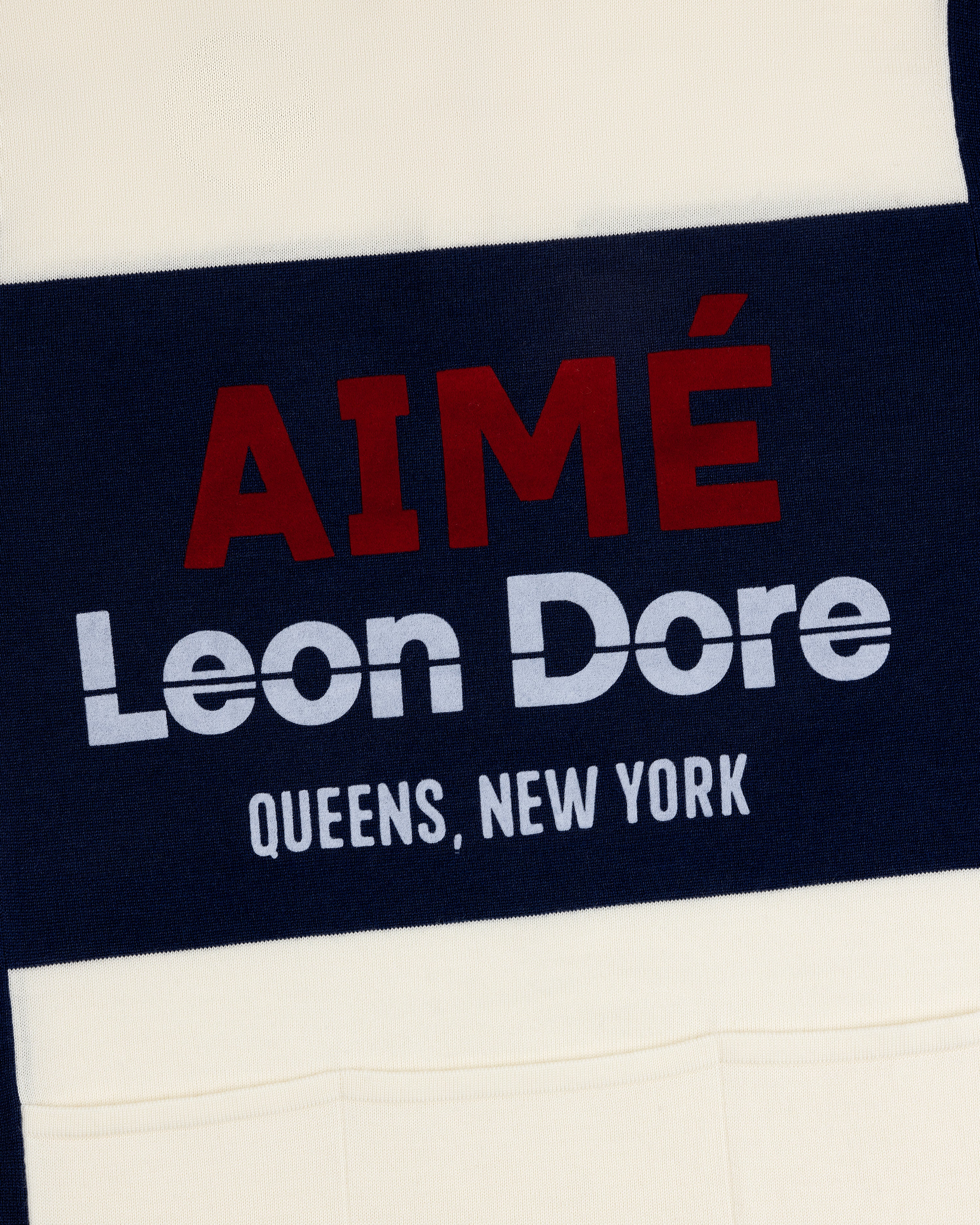 Navy and cream Merino Wool Cycling Jersey with AIMÉ Leon Dore QUEENS, NEW YORK text printed on it.