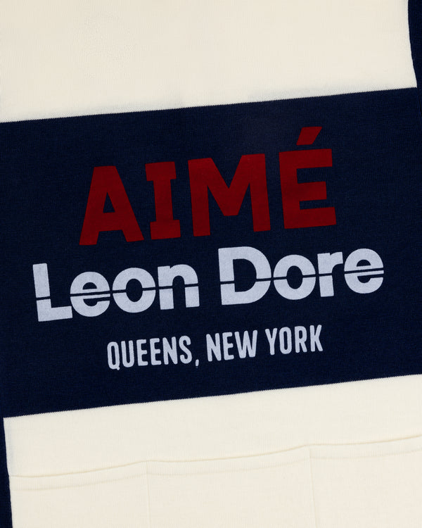 Navy and cream Merino Wool Cycling Jersey with AIMÉ Leon Dore QUEENS, NEW YORK text printed on it.