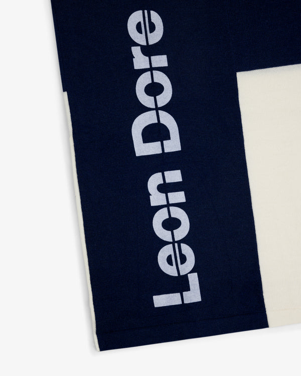 Navy Merino Wool Cycling Jersey with large white Leon Dore print beside a cream-colored section.