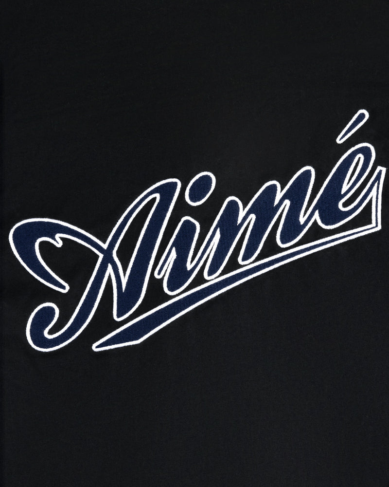 Aimé in white cursive with blue outline on black, featured on the Reversible Knit Bomber Jacket.
