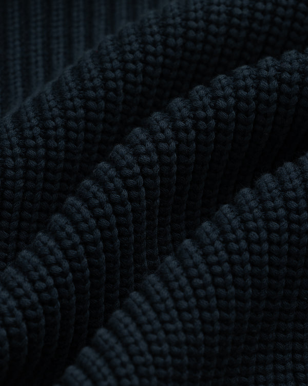 Close-up of dark, ribbed fabric with a wavy texture from the Reversible Knit Bomber Jacket.
